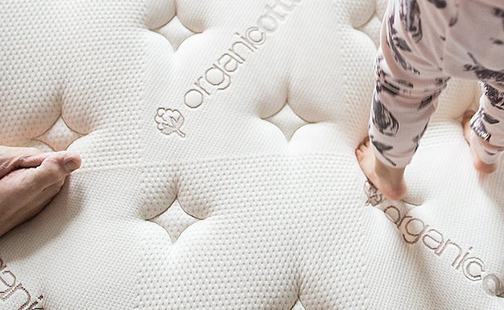 image of a child standing on a mattress - what is an organic mattress?