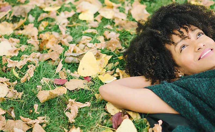 image of woman lying in grass in fall - change of seasons and sleep