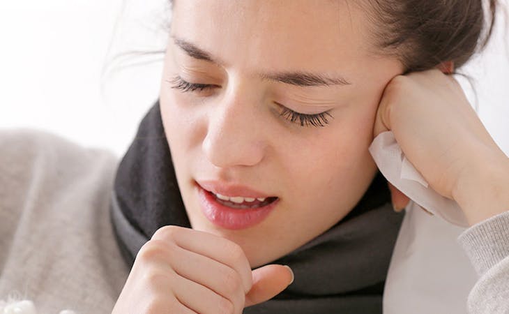 image of sick person coughing in bedroom