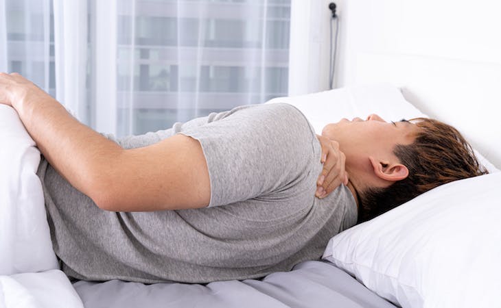 person with herniated disc sleeping in bed