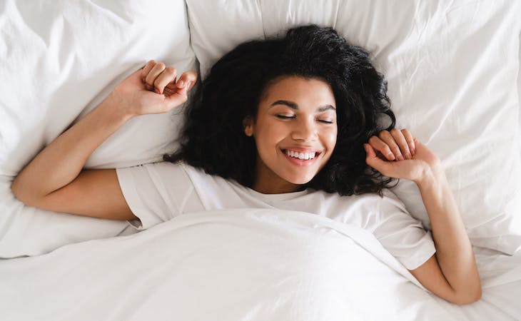 person smiling and happy in bed
