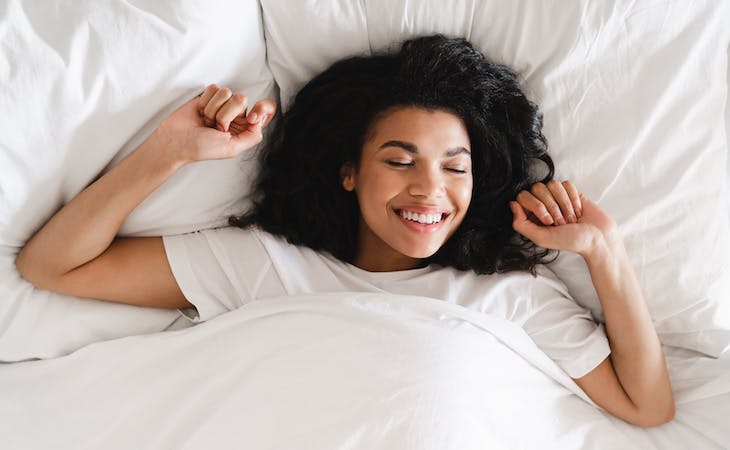 person smiling and happy in bed