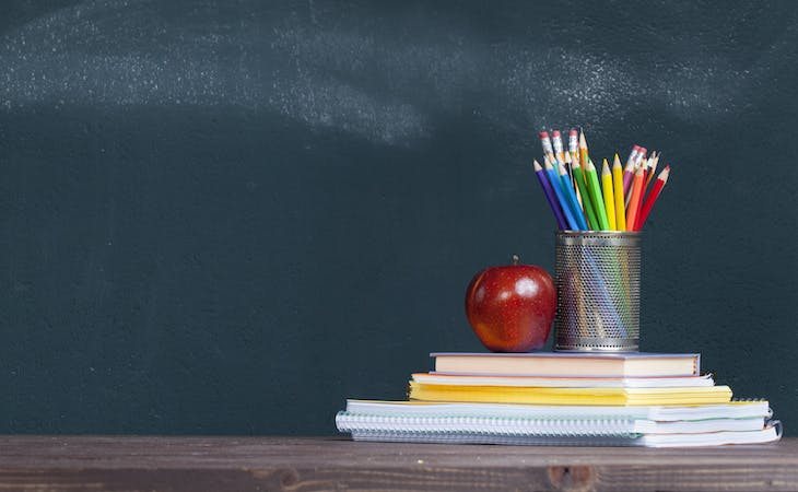 saatva teachers discount - image of chalkboard, pencils, apple, and stack of books
