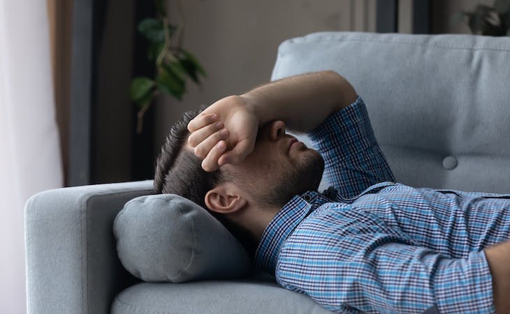 person with long covid fatigue lying on couch