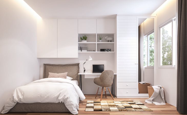 small bedroom with bbed, shelves, desk, chair, and rug