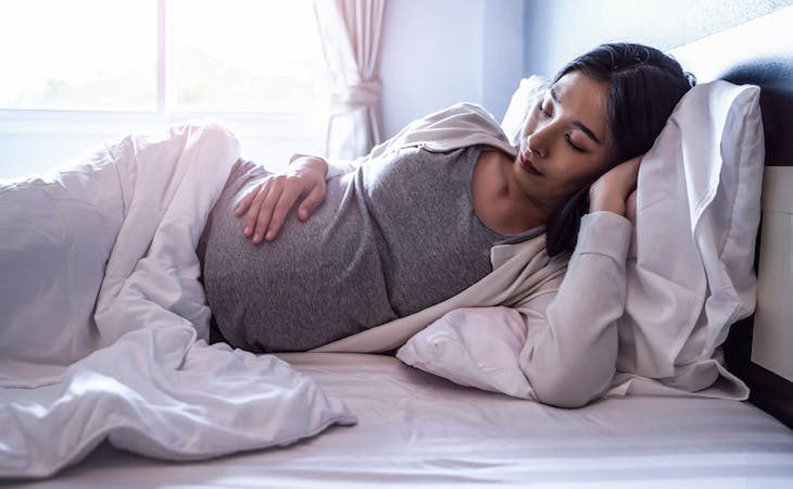 pregnant woman sleeping in bed