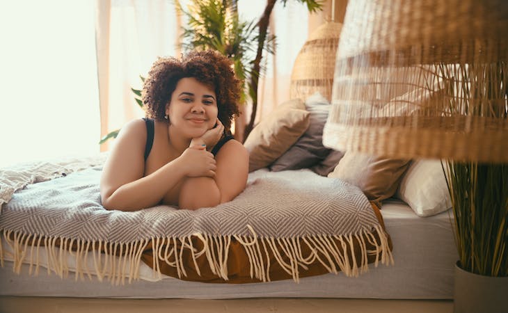 person lying in bed in eco-friendly bedroom