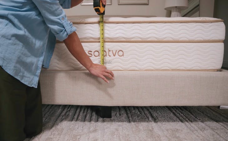 person measuring a mattress