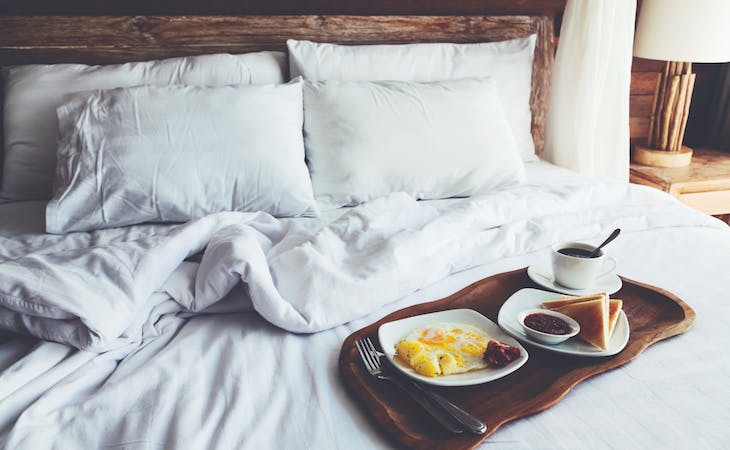 breakfast in bed featuring eggs, toast, and coffee on a tray