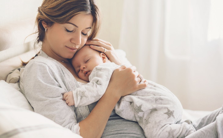 mom holding sleeping baby