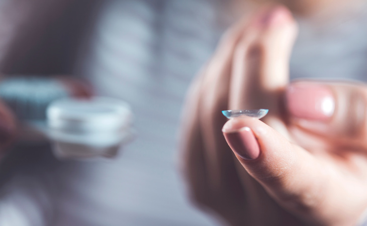 person holding contact lens on finger