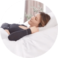 Woman resting on a mattress that is inclined by a Saatva Adjustable Base Plus