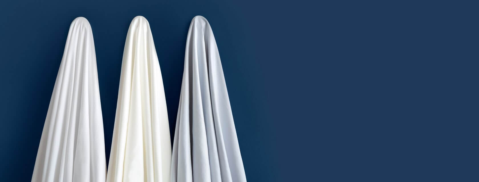 All three colors of Saatva Signature Sateen sheets.
